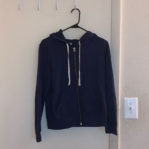 A zip up navy blue hoodie.